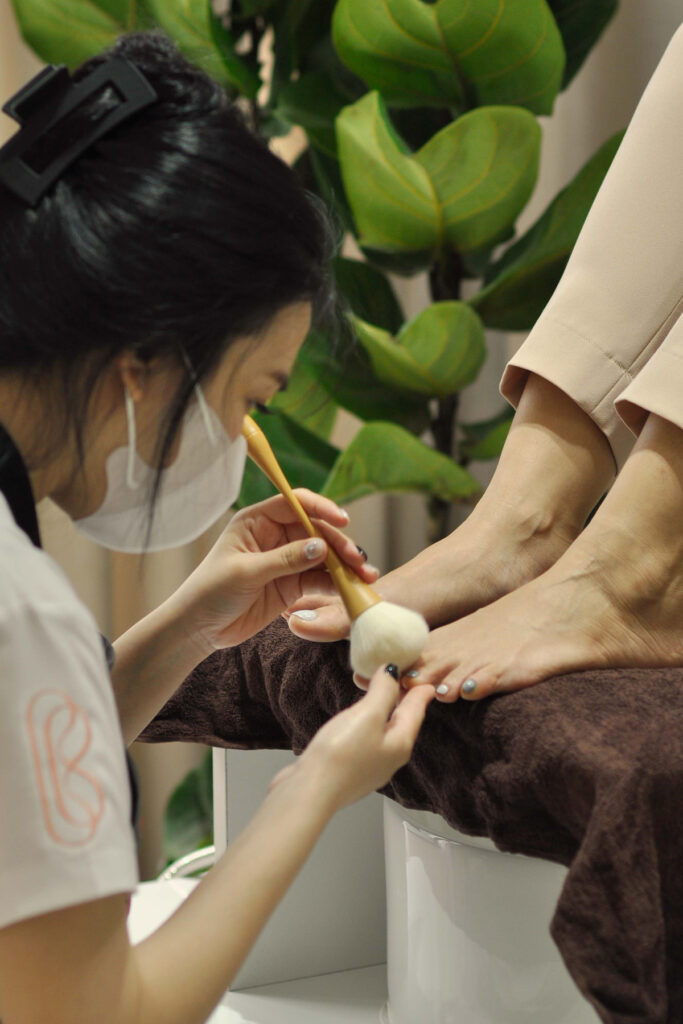 Pedicure treatment with foot scrub and nail polish application